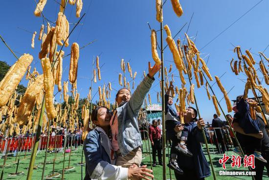 竹竿上“長(zhǎng)”油條，洛陽(yáng)民眾“摘”油條慶豐收